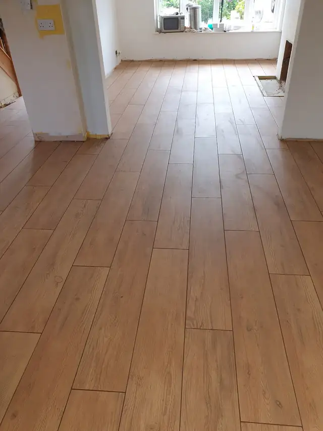 Wood effect plank floor tiles laid through a long room