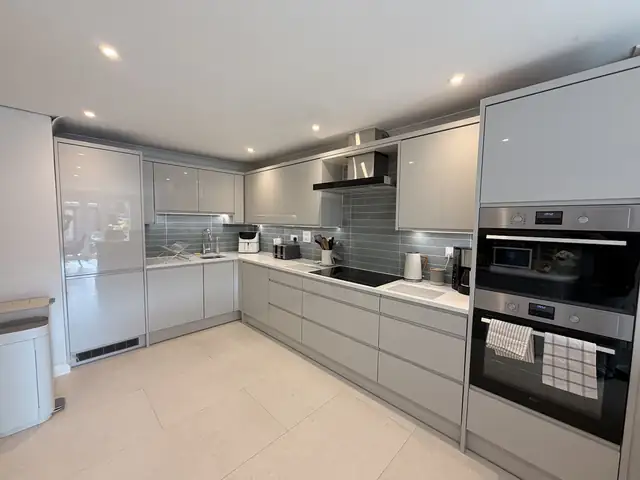 Grey kitchen with tiled splashback and large light floor tiles